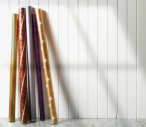 Rolls of Holiday Wrapping Paper Against Wall