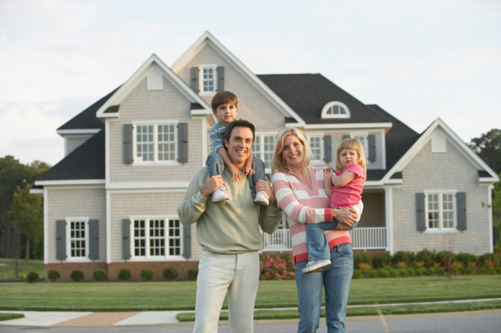 Happy Family in Front of Their Home